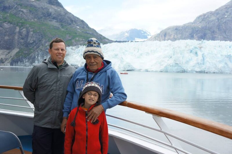 Eric with his father-in-law and son on a boat in Alaska with a glacier behind them