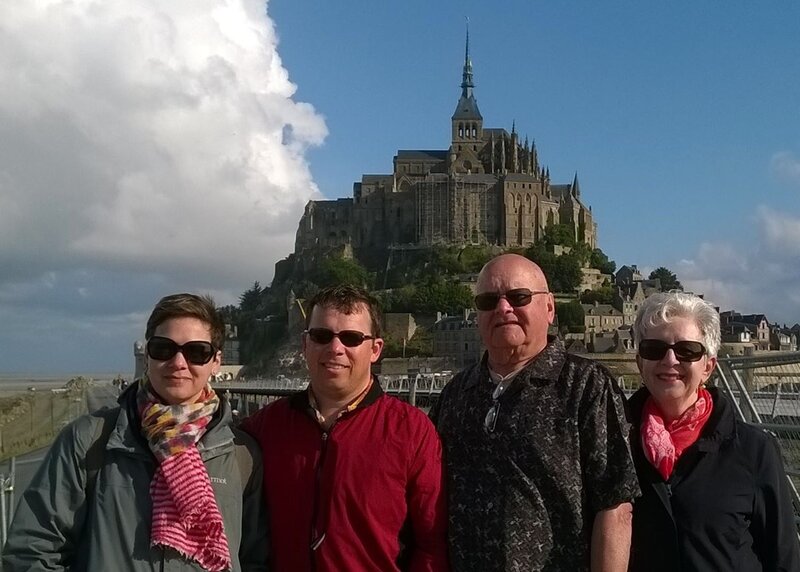 Eric with his parents and sister in front of Mont-Saint-Michel in France